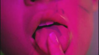 Neon lights shine upon the oiled babe as she passionately rubs herself